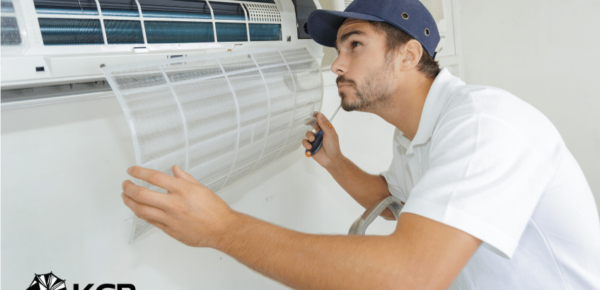 Air conditioning maintenance technician examines residential HVAC system.