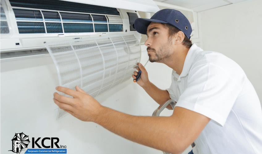 Air conditioning maintenance technician examines residential HVAC system.