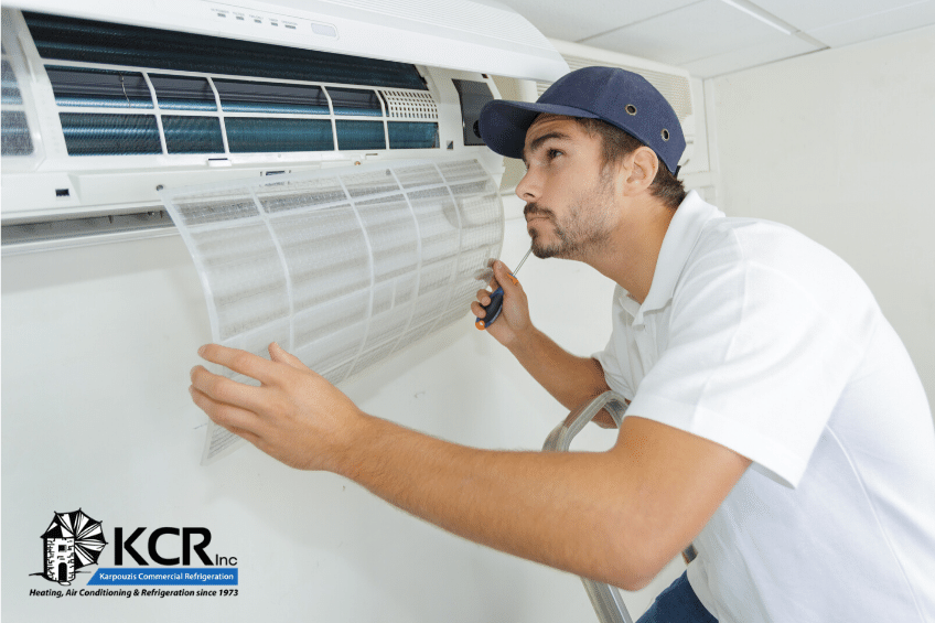 Air conditioning maintenance technician examines residential HVAC system.